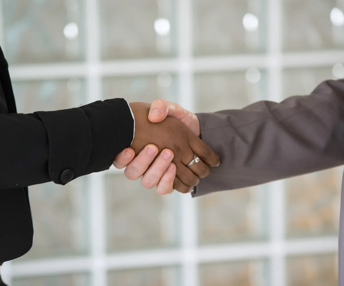 Two people shaking hands in a professional setting